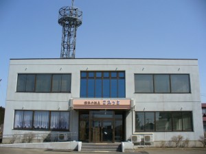 白いモダン建築の介護施設外観。正面玄関と大型窓が特徴。